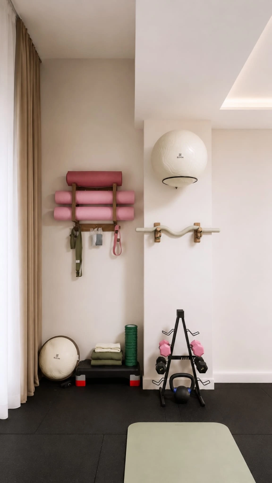 Ekipman duvarı: mat rafı, pilates topları, dambıllar ve direnç bantları
